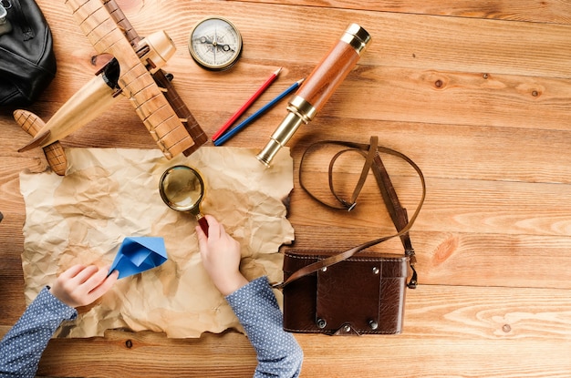 Child plays a journey with a map and a magnifying glass