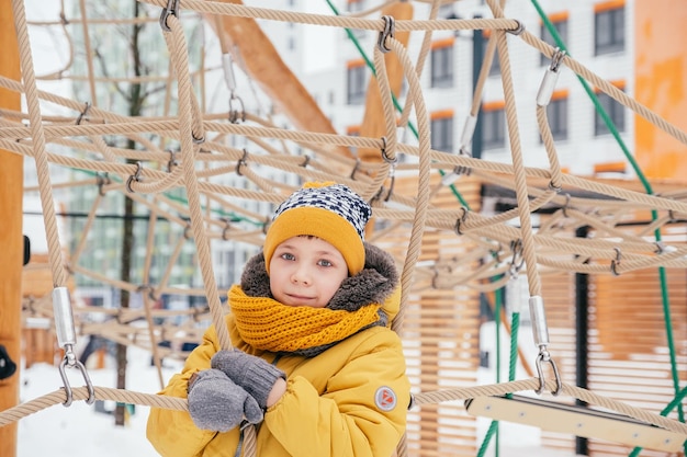 Child plays on the playground on a snowy winter day