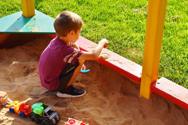 Child plays in the sandbox outside 