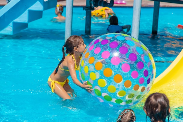 The child plays with a ball in the pool. Selective focus. Kid.