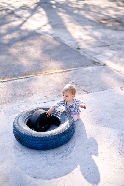 上から見た駐車場で子供が車のタイヤで遊ぶ