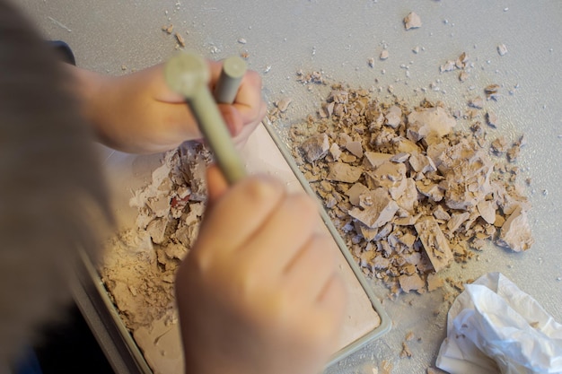 A child plays with a children's set for excavation of crystals and stones