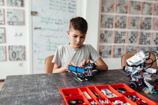 Il bambino gioca con un giocattolo robotico assemblato dal designer