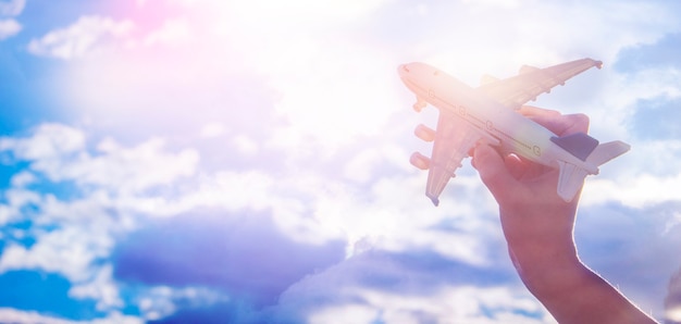 Child plays with a toy airplane in the sunset and dreams of journey.