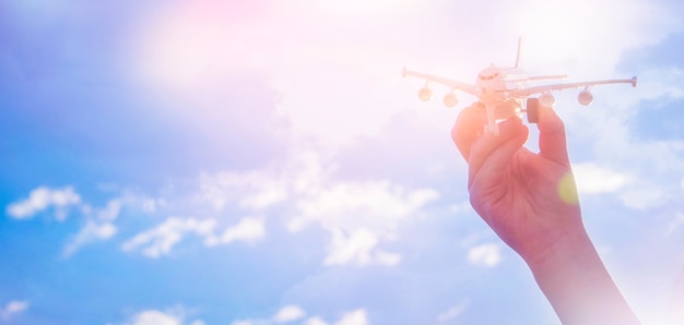 Child plays with a toy airplane in the sunset and dreams of journey