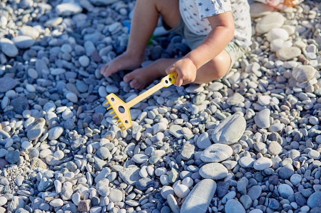 어린이가 해변에서 장난감과 자갈을 가지고 노는 레크리에이션 놀이의 개념과 어린이의 운동 능력 개발 고품질 사진