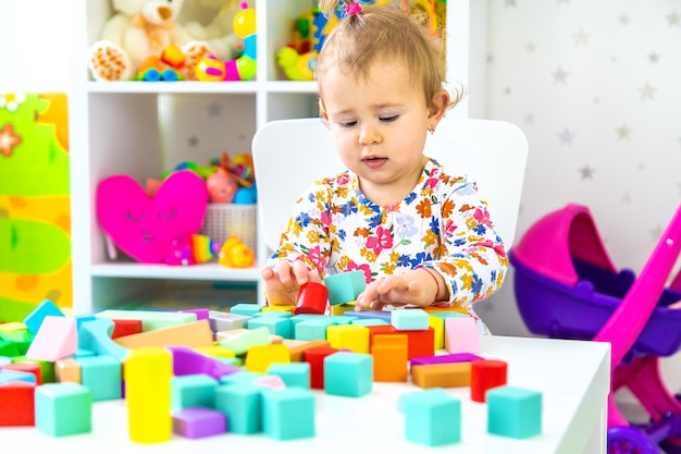 The child plays with toys in the room. Selective focus. Baby.