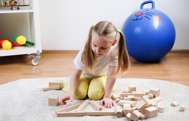 child plays with wooden cubes  on floor