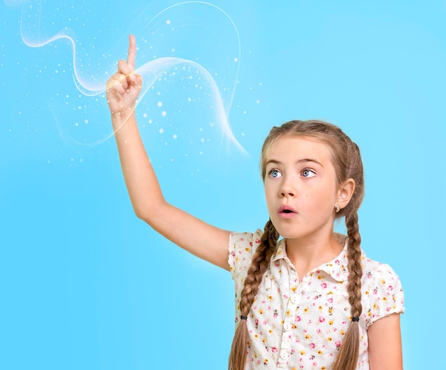 child pointing his finger up on a blue background