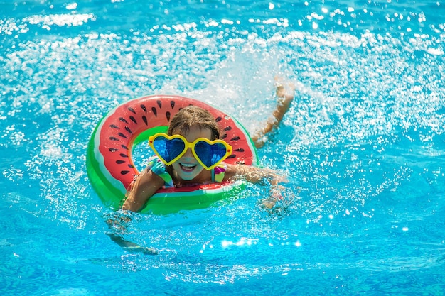 The child in the pool swims in a circle. Selective focus.