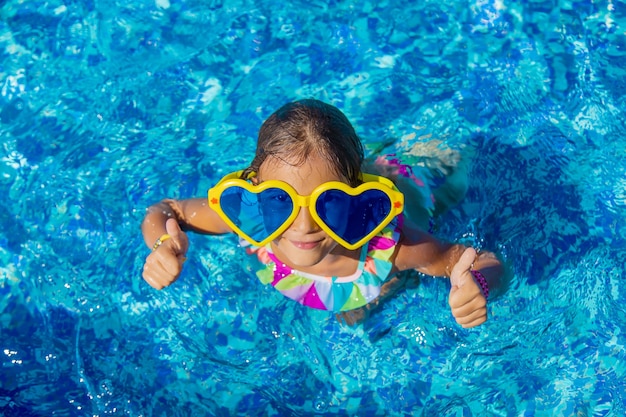 Child in the pool wearing big glasses. Selective focus. Kid.