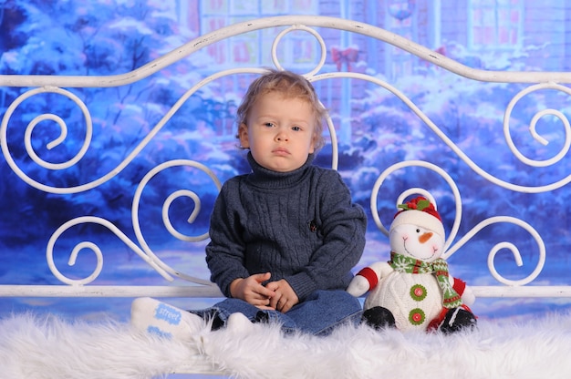 Child posing on Christmas with toy snowman