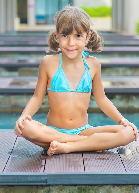 The child practices yoga in the summer