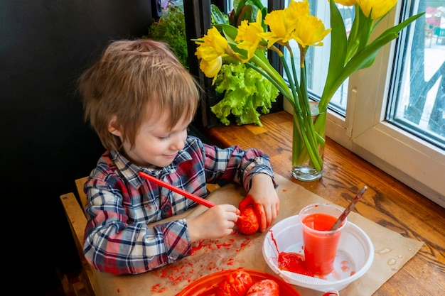 The child preparing for Easter Paint eggs Red paint egg