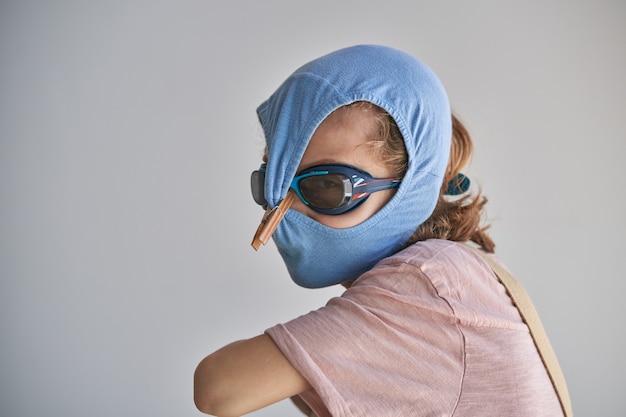 Child protecting himself with swimming shorts and goggles\
against possible infection