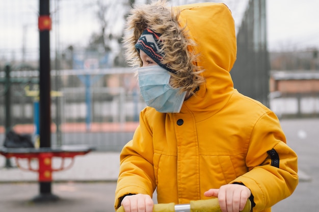 Foto bambino in una maschera protettiva in un parco