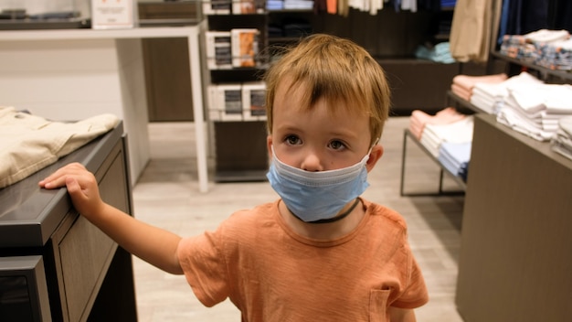 Child in a protective mask in a store