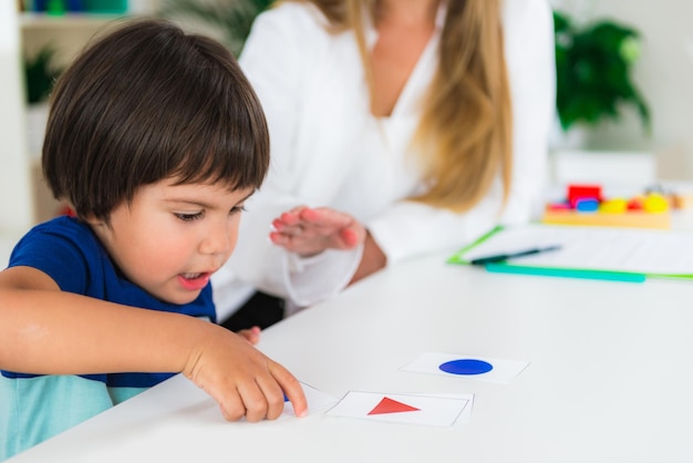 Foto bambino di psicologia infantile che fa test logici con le carte