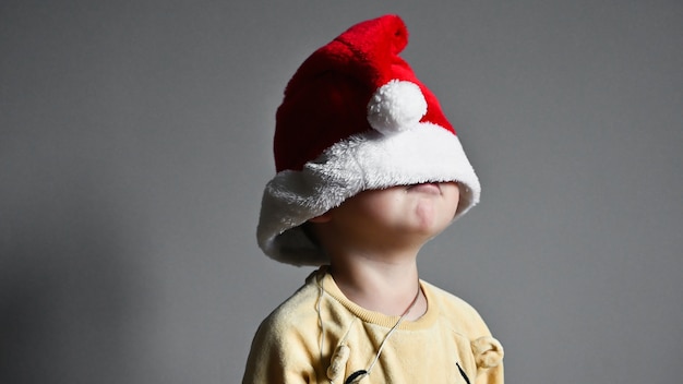 The child pulled a Christmas hat over his eyes