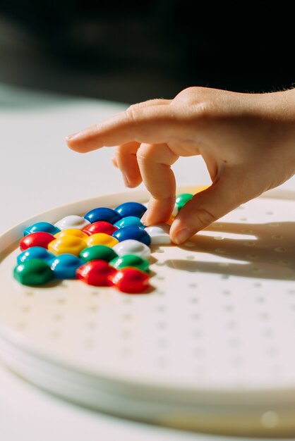 The child pulls out the mosaic pieces from the plastic mold.