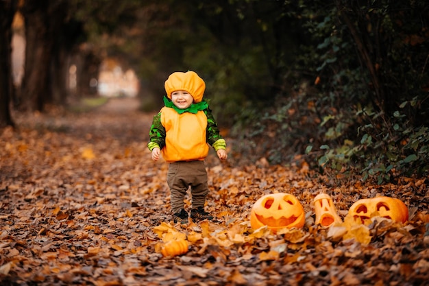 ハロウィンの公園を探索するカボチャの衣装を着た子供