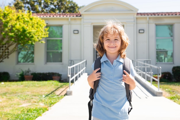 Ученик ребенка с рюкзаками в парке возле школы. Школьник с рюкзаками на открытом воздухе.