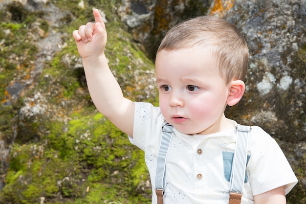 Photo a child raises his finger to speak in park