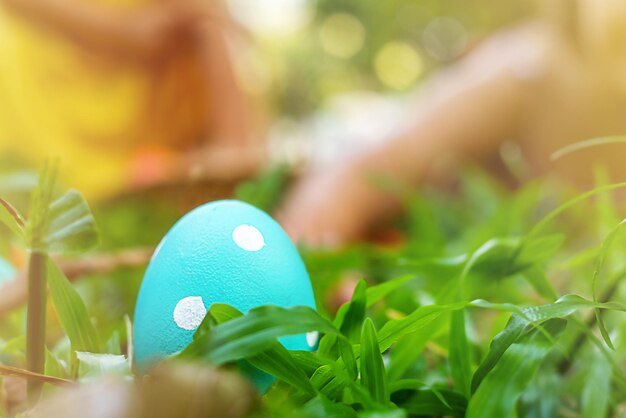 Foto il bambino raggiunge le uova di pasqua sull'erba nel cortile