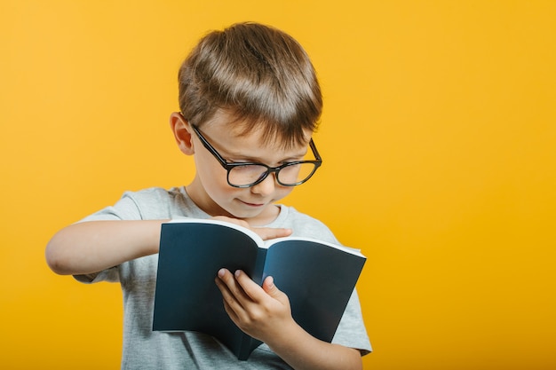 Фото Ребенок читает книгу у яркой стены