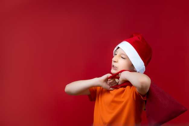 A child in a red Santa hat threw a bag over his shoulder