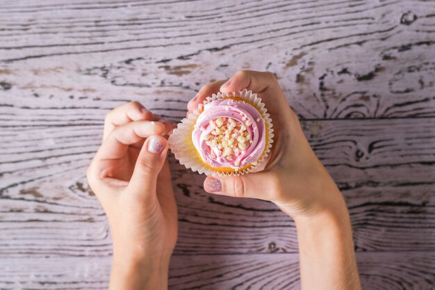 Foto il bambino rimuove il pacchetto dal cupcake sul tavolo