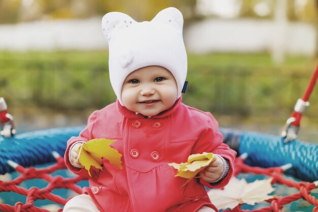 黄色い紅葉のブランコに乗る子供