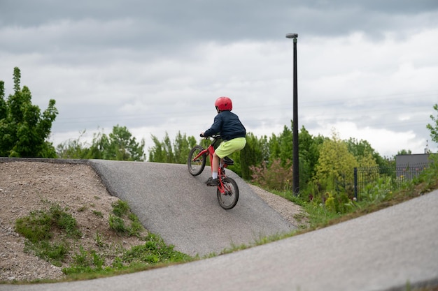 Foto bambino che guida la sua bici bmx su una pista di pompaggio