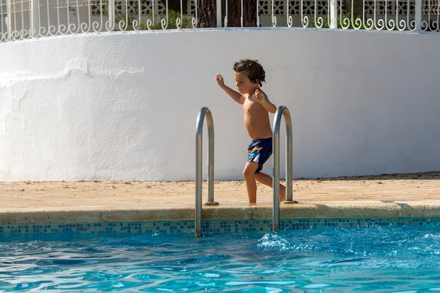 Child running and having fun in a swimsuit at the edge of the pool