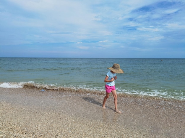 晴れた日に海のビーチで水の上を走る子供