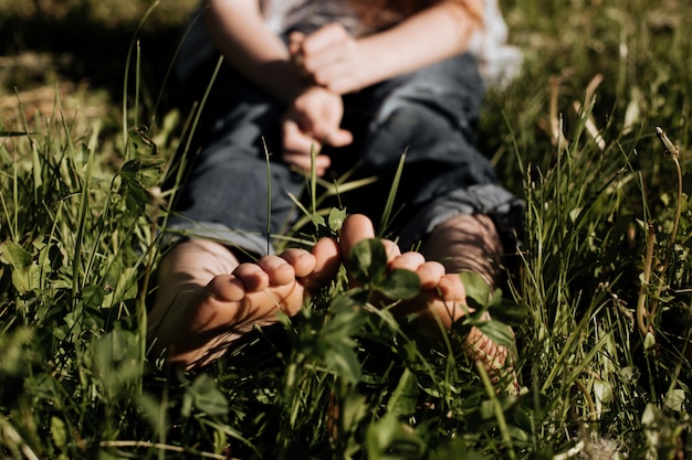 A child's bare feet in the green grass on a Sunny day