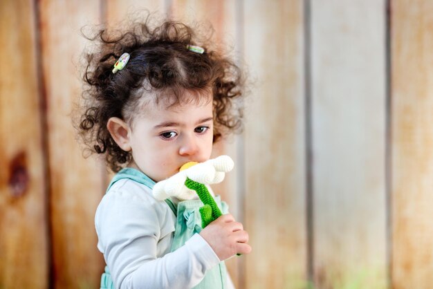 スタジオで自然の美しさを探求する細い花に興味深い子供の触り