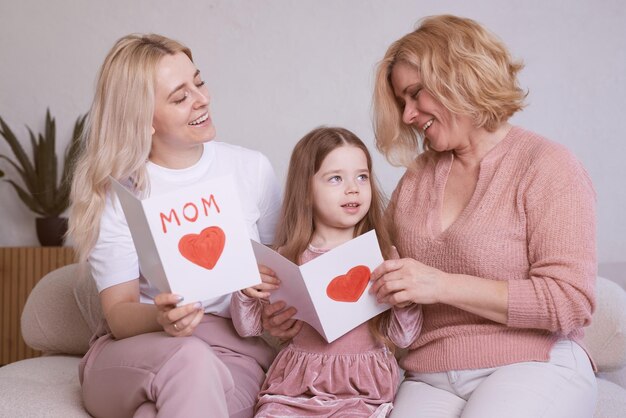 Child's daughter congratulates mother and grandmother gives heartshaped cards