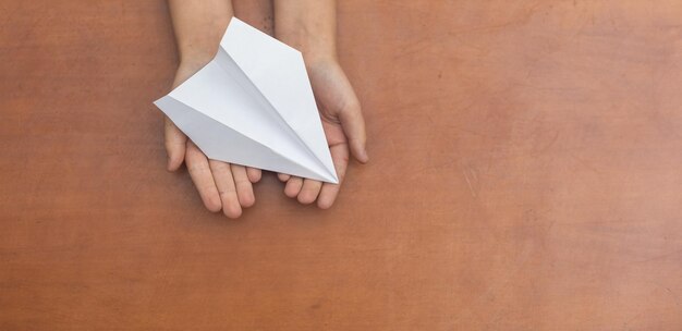 Child's Dream. Child's hand launching white paper airplane