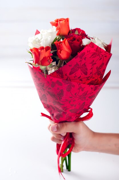 Child's hand holding bouquet of roses