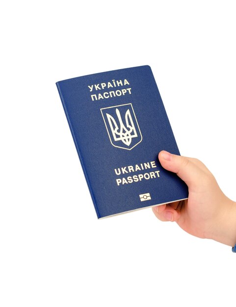 A child's hand holds a biometric passport of Ukraine isolate on a white background