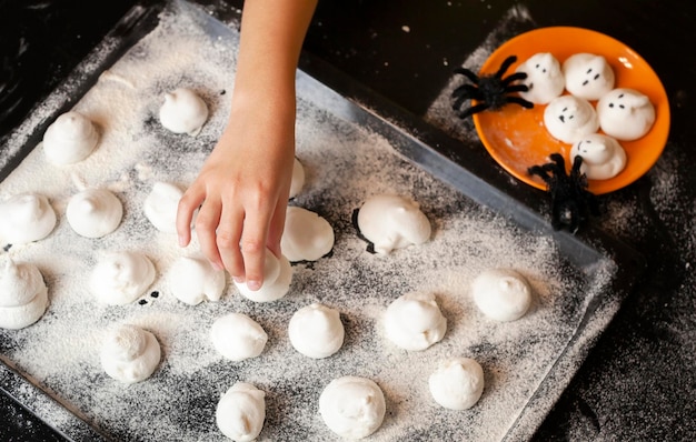 the child's hand reaches for the baking sheet. halloween concept