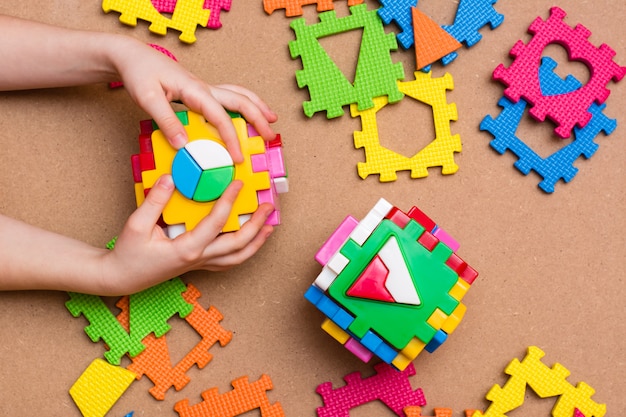 The child's hands are holding puzzle sorters in the form of cubes