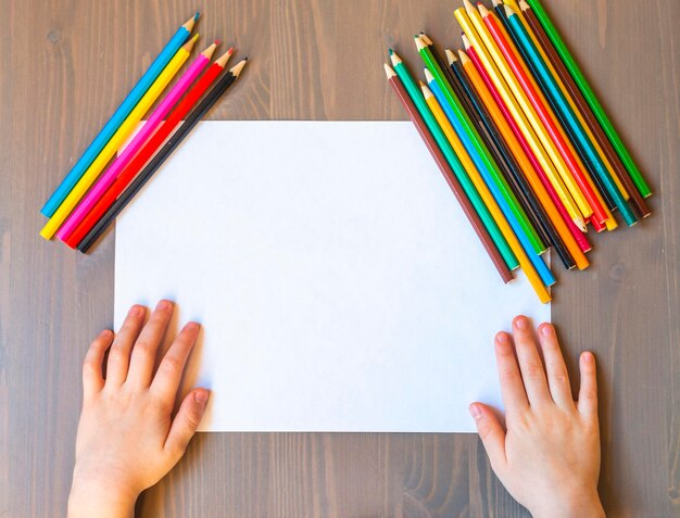 Child's hands are painted with colored pencils on a white sheet of paper