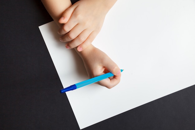 Foto le mani del bambino sopra bianco vuoto il foglio di carta