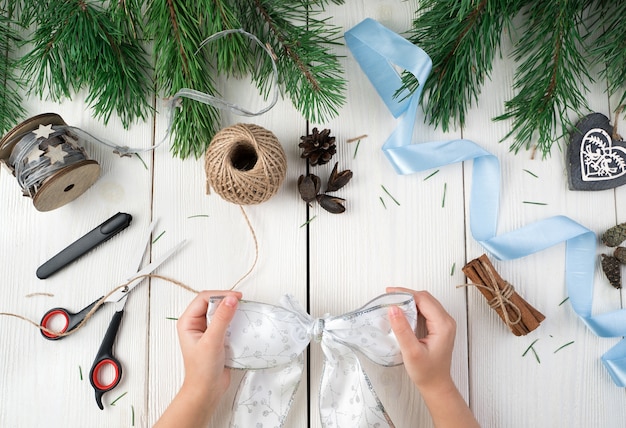 Child's hands holding a Christmas bow.