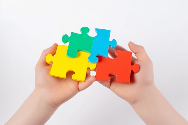 A child's hands holding colorful puzzle pieces Autistic Pride Day