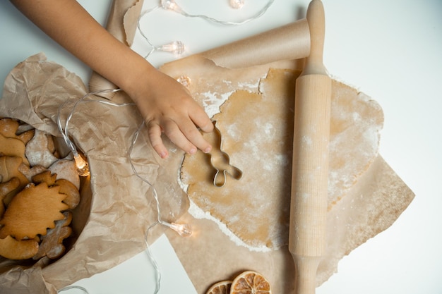 The child's hands make cookies on the dough with a mold