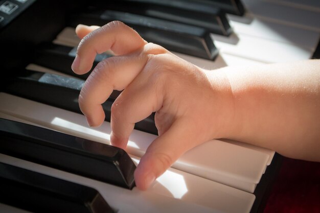 Руки ребенка на фортепиано.