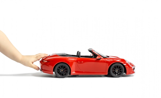 Child's hands pushing red Porsche Car